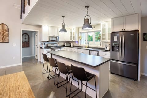 Closer view of the kitchen and island, table top ice machine for your favorite drinks, air fryer/toaster/bake/combo oven, everything you need to make family/holiday meals are here.
