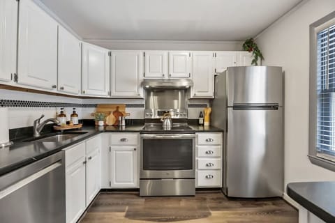 Stylish kitchen with fridge, oven dishwasher, plenty of counter space, and a cozy breakfast bar