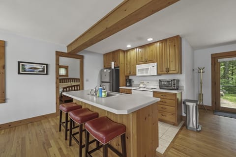 Full kitchen right photo: Full kitchen with breakfast bar, stainless appliances, and natural wood cabinetry.