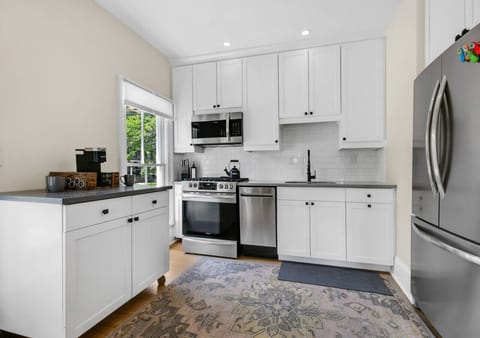 Another view of the kitchen showing cabinetry, counters, and open shelving that showcases the functional layout.