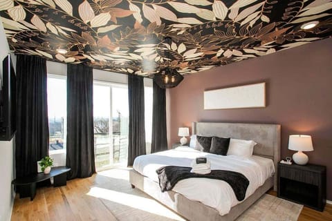 The primary bedroom features a king bed with modern luxury decor