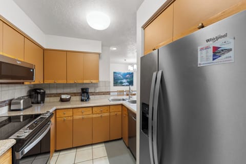 Full kitchen with stainless steel appliances and breakfast bar for casual dining.