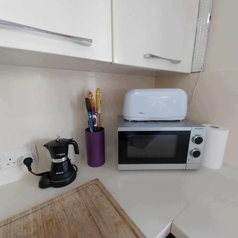 Kitchen top with micro wave oven, coffee machine, toaster, block cooking knives.