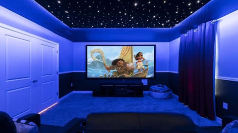 Private theater room with starry ceiling, big screen, and cozy seating for all.