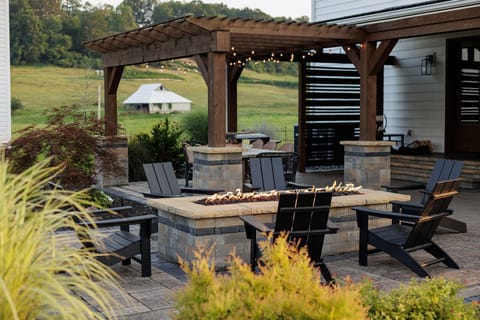 The private patio features a fire pit table, outdoor dining and a hot tub!