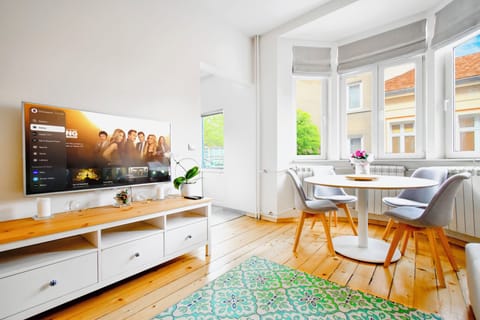 Relax in the bright and inviting living room, featuring stylish furniture, and a dining space perfect for enjoying meals together.