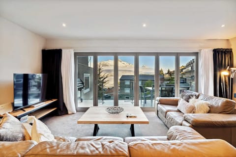 Spacious living area with leather sofas and spectacular mountain views.