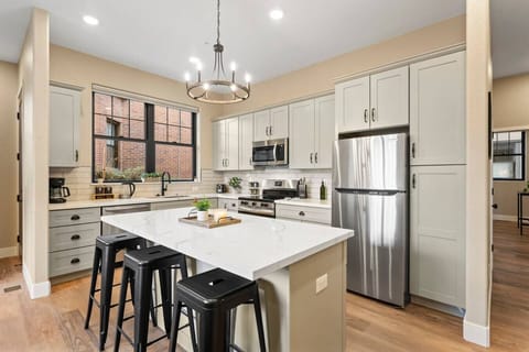 Cook, dine, and gather in this stunning modern kitchen featuring sleek stainless steel appliances, a spacious island with bar seating, and plenty of natural light.