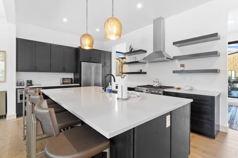 Full kitchen featuring stainless steel appliances, large island, and breakfast bar seating 4 for casual dining.