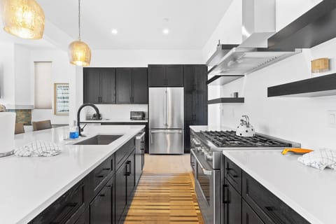 Full kitchen featuring stainless steel appliances, large island, and breakfast bar seating 4 for casual dining.