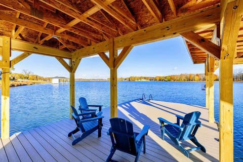 Covered dock with Adirondack chairs overlooking a serene lake, perfect for relaxing and enjoying the view.