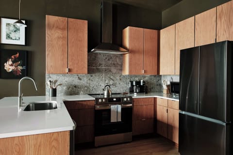 This sleek, modern kitchen features ample counter space and beautiful tilework, perfect for cooking or hosting with ease.