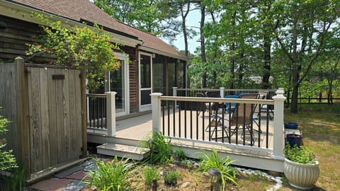 Backyard with deck, outdoor shower, charcoal grill, picnic table and hammock