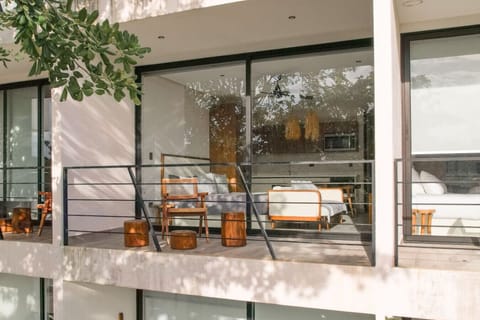 Balcony with wood seating and view into cozy bedroom.