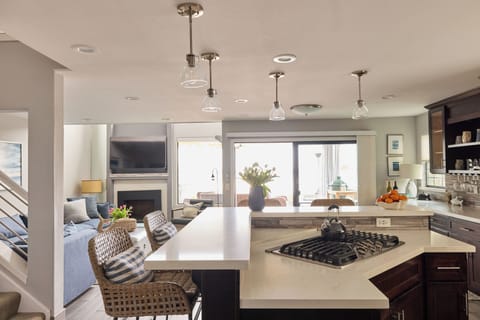 View from front door and open plan kitchen, bar and living room to patio and the cove.