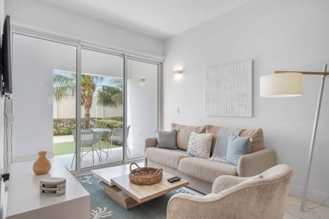 Bright living space filled with natural light, creating a cozy atmosphere for relaxation - Soft textures & stylish decor make this space inviting & comfortable for any moment - Glass doors open to a patio, bringing in fresh air & outdoor charm