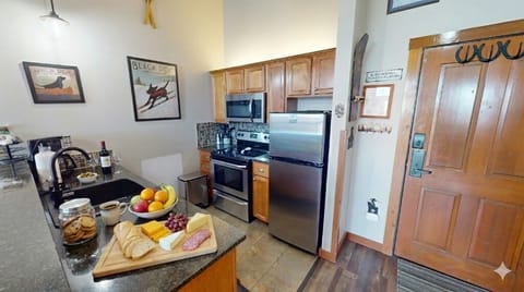 Full kitchen setup with coffee maker, oven, microwave, and breakfast bar seating.