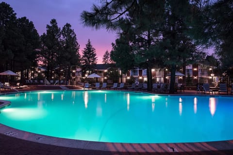 Unwind at dusk as the pool glows under twilight skies.