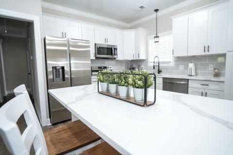 Modern white kitchen with quartz island and stainless appliances