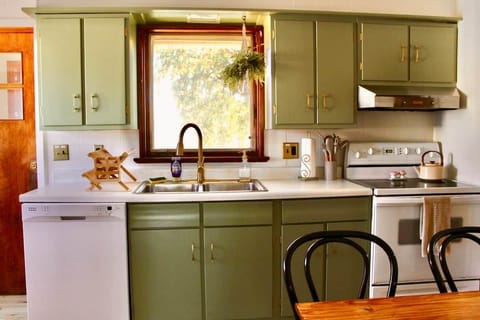 Kitchen has baking sheets, pots, pans, silverware, plates, bowls, glasses, containers, and more