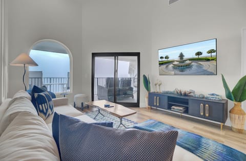 Cozy living room with a sectional sofa, wide-screen TV, and balcony access.