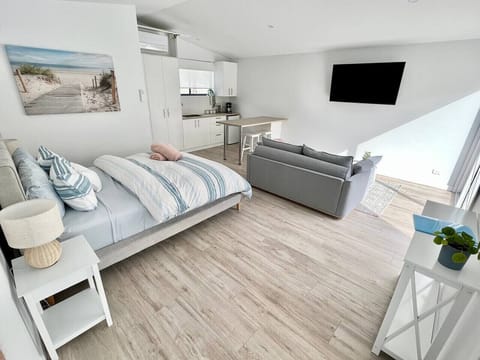 Bright studio with kitchenette, cozy seating, and modern beachy style