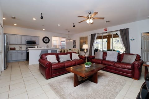 Gather in the open-plan lounge with comfortable leather sofas, flat-screen TV, and direct pool deck access – ideal for family relaxation.