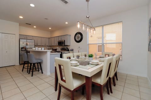 Fully equipped kitchen with breakfast bar seating and glamorous dining suite