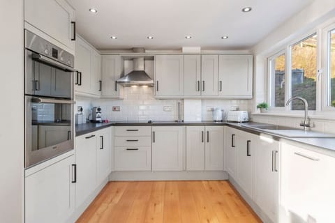 Swn y Don - Fully Equipped Modern Kitchen A large, modern kitchen with double ovens, ample storage, and stunning views, designed for convenience and style.