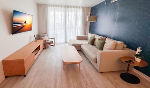 Bright living room with a stylish accent wall and comfortable seating for relaxing moments.