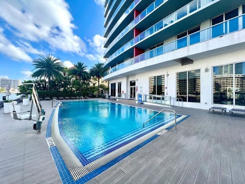 Outdoor pool surrounded by high-rises and cityscape views.