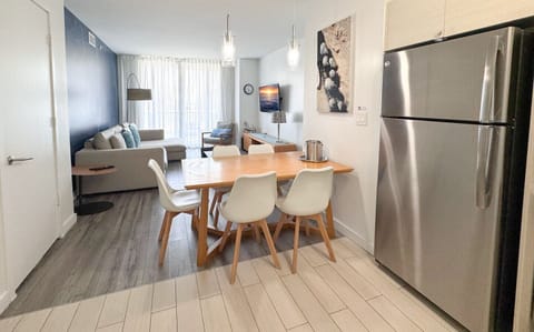 Modern dining area connected to a fully equipped kitchen. and living room