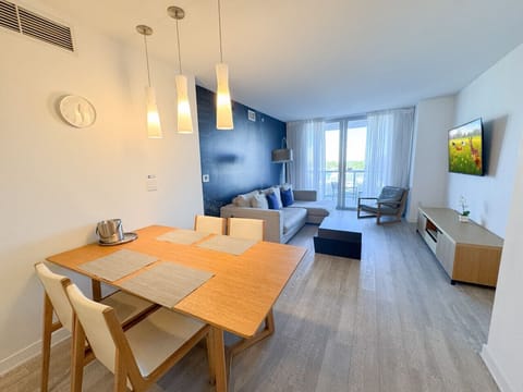 Modern dining area connected to a fully equipped kitchen.
