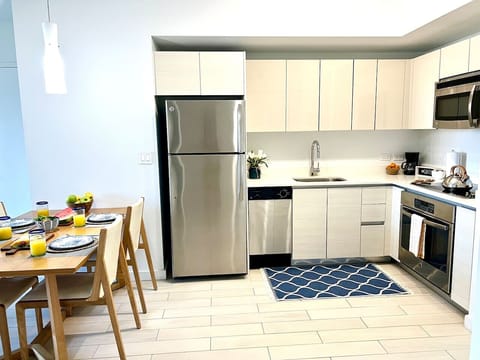 Fully equipped kitchen with stainless steel appliances and a stylish backsplash.