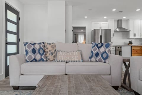 The cozy couch in the living room offers natural light and a fireplace, with easy access to the kitchen and three doors to relax on the wrap around deck!