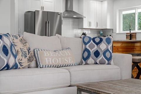 The cozy couch in the living room offers natural light and a fireplace, with easy access to the kitchen for meals and movies!