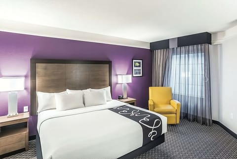 Unwind in a crisp king bed with cozy reading chair.