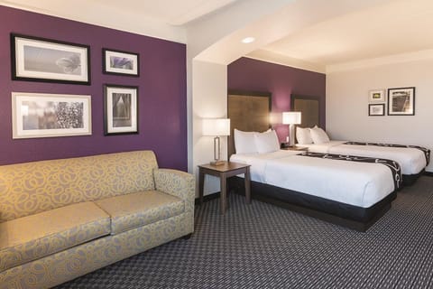 Lounge comfortably with a sofa nook beside crisp, inviting beds.
