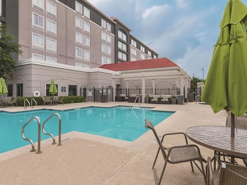 Sip coffee poolside at shaded tables and loungers.