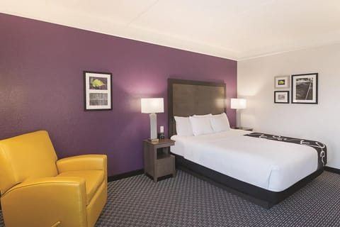 Recharge in a quiet corner room with soothing purple accents.