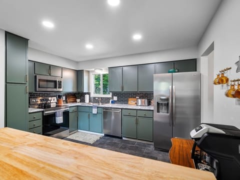 A thoughtfully designed kitchen, showcasing a harmonious blend of modern appliances and classic cabinetry. The muted tones create a serene atmosphere.