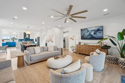 The living room, dining area, and kitchen flow seamlessly together, ensuring no one misses a moment of conversation, whether cooking, dining, or relaxing.