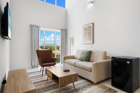 Relax in a bright and airy living area with tall ceilings and cozy seating - Catch your favorite shows on the smart TV or soak up the views from the large windows - A perfect spot to recharge after a day of exploring or unwinding with loved ones