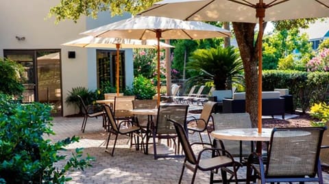 Enjoy morning coffee outdoors beneath shaded, breezy umbrellas.