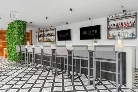The Elser - Outdoor dining area with modern tables, chairs, and bar