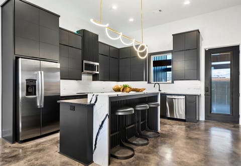 This sleek, modern kitchen is a chef's dream with high-end appliances, a spacious island for casual dining or meal prep, and clean, minimalist finishes that tie the space together.