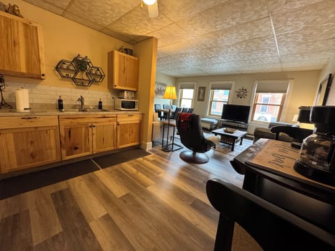 Open concept kitchen and living room with views of Main Street from windows.