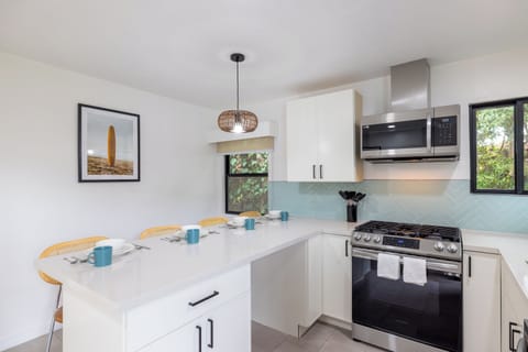 full kitchen with stove, oven, microwave, a bar with stools