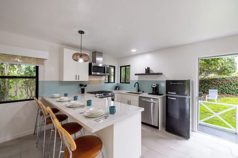 full kitchen with full-sized appliances and a bar with stools