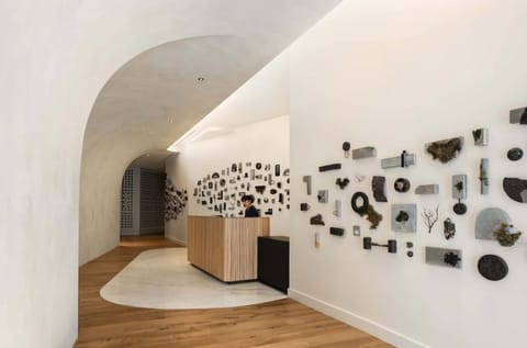 Step into a serene, gallery-like lobby with warm wood tones.